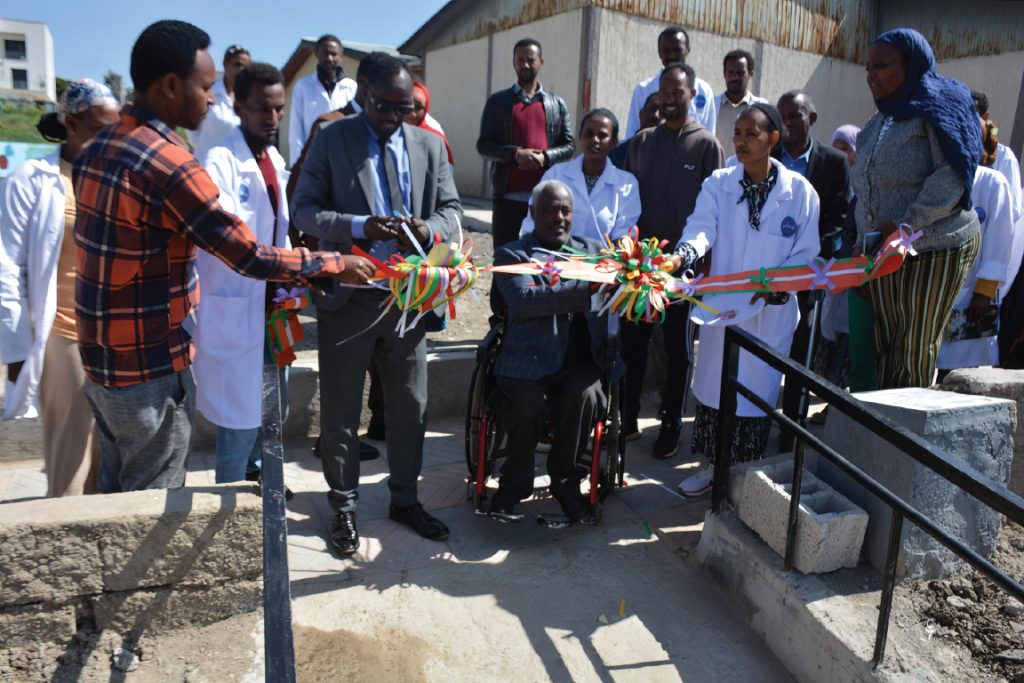 People take part in a ribbon-cutting ceremony at an accessible ramp.