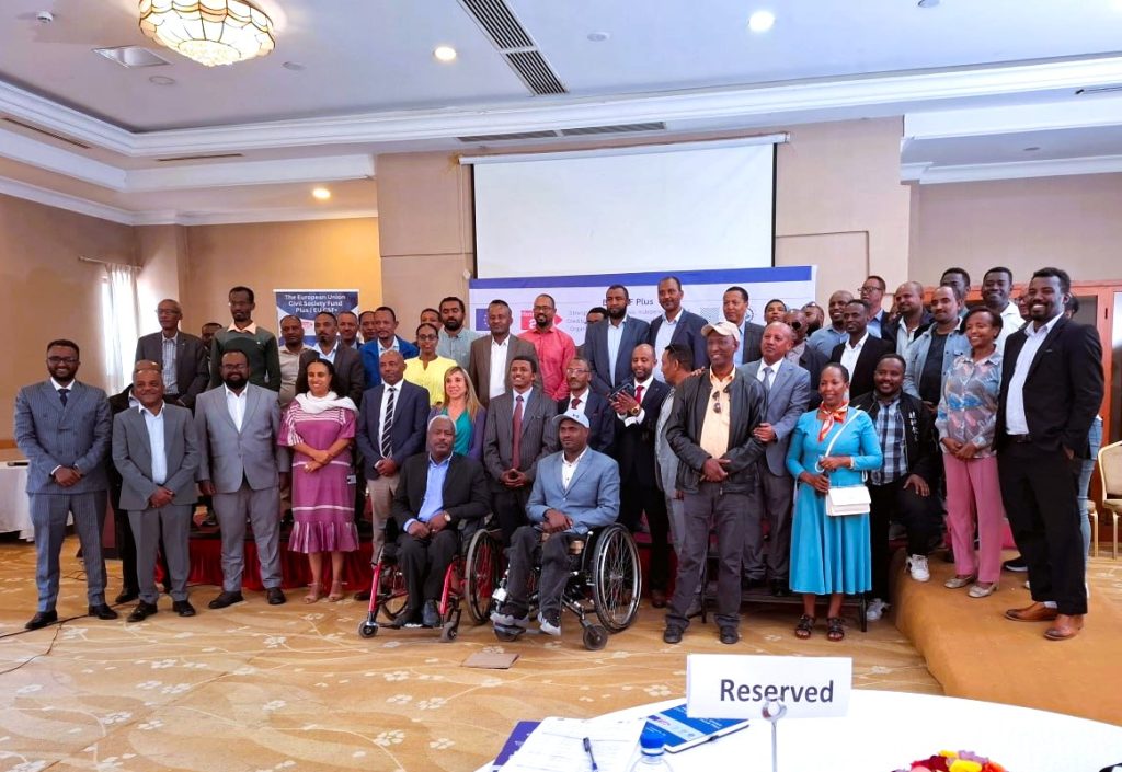 Partners and participants gather for the Inclusive Education for All project launch. Two participants in the front row use wheelchairs.